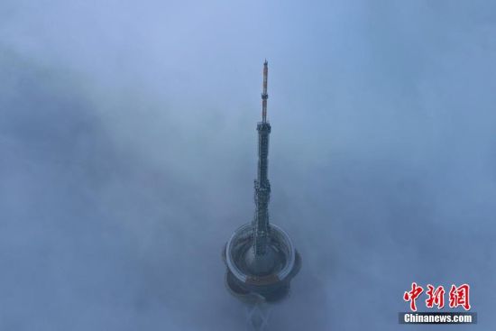 　3月27日，河南省郑州市气象台公布大雾黄色预警信号。上午，郑州城区被雾笼罩，高架桥快速路远端在雾中仿若没有尽头，城市地标之一的“中原福塔”在雾中若隐如现，空中俯瞰仅剩塔顶。中新社记者 李超庆 摄