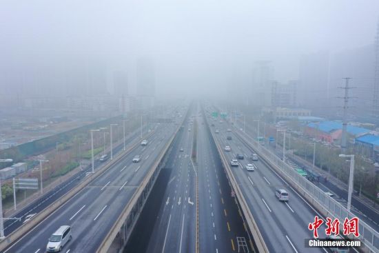 　3月27日，河南省郑州市气象台公布大雾黄色预警。上午，郑州城区被雾笼罩，高架桥快速路远端在雾中仿若没有尽头。图为郑州城市快速路北三环高架桥远端在大雾中“消失”。中新社记者 李超庆 摄
